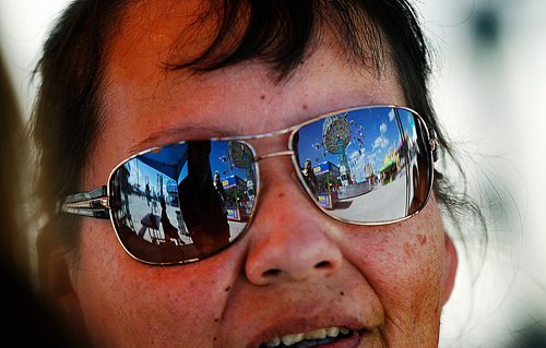 PHIL HOSSACK / WINNIPEG FREE PRESS -Seeking shade, Grassy Narrows resident Deborah Landon's glasses refelct the midway at the Red River Exhibition Tuesday afternoon. See Maggie Macintosh's story.- June 19, 2018