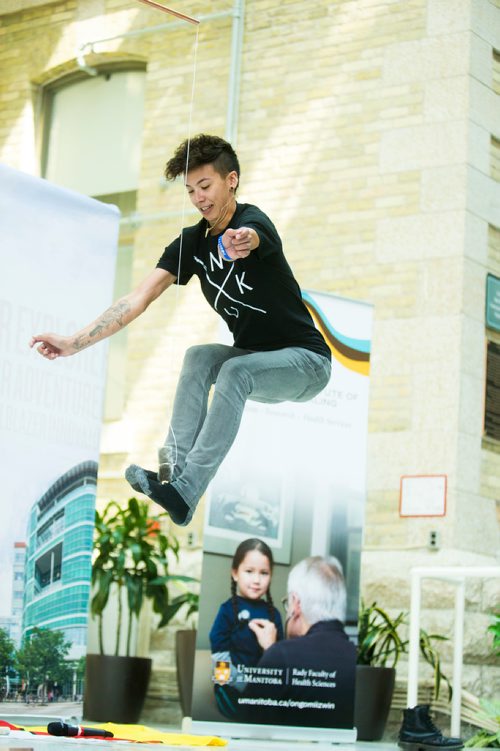 MIKAELA MACKENZIE / WINNIPEG FREE PRESS
Inuk Maxine Angoo demonstrates one of three high-kick Inuit games at Indigenous Peoples Day festivities at the University of Manitoba Bannatyne campus in Winnipeg on Thursday, June 21, 2018. 
Mikaela MacKenzie / Winnipeg Free Press 2018.