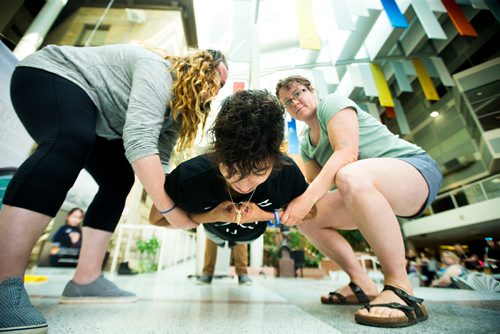 MIKAELA MACKENZIE / WINNIPEG FREE PRESS
Inuk Maxine Angoo demonstrates Inuit game called Airplane where the player lays their body stiff for as long as possible while being held up by three other people, at Indigenous Peoples Day festivities at the University of Manitoba Bannatyne campus in Winnipeg on Thursday, June 21, 2018. 
