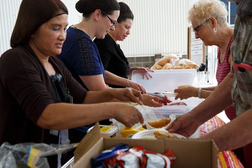 MIKE DEAL / WINNIPEG FREE PRESS
Employees (l-r) Zosima Revelo, Linda Slocombe, Nikki Canavan, at the Real Canadian Superstore on St. James hand out a free lunch consisting of a sandwich, egg salad, an egg roll, a bag of chips and a can drink.
180622 - Friday, June 22, 2018.