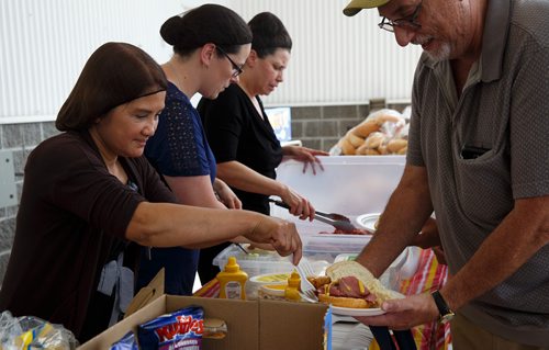 MIKE DEAL / WINNIPEG FREE PRESS
Employees (l-r) Zosima Revelo, Linda Slocombe, Nikki Canavan, at the Real Canadian Superstore on St. James hand out a free lunch consisting of a sandwich, egg salad, an egg roll, a bag of chips and a can drink.
180622 - Friday, June 22, 2018.