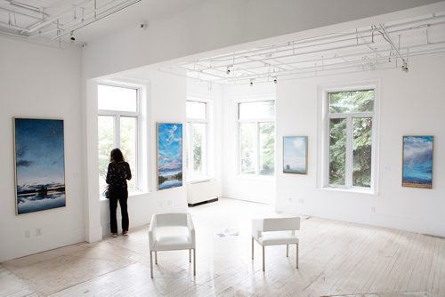 ANDREW RYAN / WINNIPEG FREE PRESS A museum patron takes a break in a gallery of paintings at La Maison des artistes visuels francophones in St. Boniface for an event celebrating the impressionists on June 24, 2018.