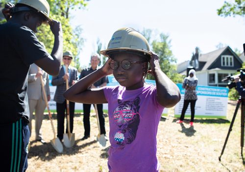 ANDREW RYAN / WINNIPEG FREE PRESS Seyanabou Diallo dons her ceremonial gold hard hat before breaking ground at her new home on June 27, 2018. The St. Boniface Habitat for Humanity project will be the first home the organization has built in the area since 2012.