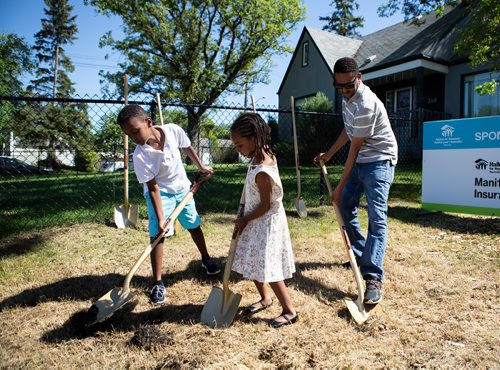 ANDREW RYAN / WINNIPEG FREE PRESS Deborah Haile, centre, her brother Yoel, and father Tsegay Teame break ground on their new home's foundation in St. Boniface on June 27, 2018. The project marks the first time Habitat for Humanity has acquired land in the area in six years.