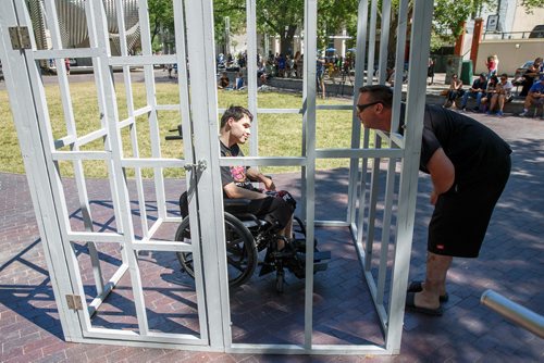 MIKE DEAL / WINNIPEG FREE PRESS
Tyson Sylvester put himself into a mock jail set up in Old Market Square Thursday over the lunch hour. Rob Pollok talks to Tyson after listening to an audio recording by Tyson talking about what it is like to live in isolation, without hope of pursuing his dreams. Rob also has a daughter with disabilities. 
180628 - Thursday, June 28, 2018.