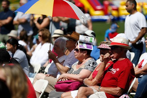 JOHN WOODS / WINNIPEG FREE PRESS
The spectators coverup whatever way they can during a citizenship ceremony on  Canada Day at Assiniboine Park, Sunday, July 1, 2018.