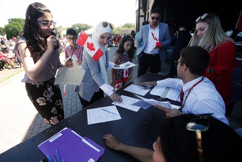 JOHN WOODS / WINNIPEG FREE PRESS
Mahmoud Al-Abedi and Rola Elsousi and their children, from left, Marah , Naser and Zaina sign their citizenship documents at a ceremony on  Canada Day at Assiniboine Park, Sunday, July 1, 2018.