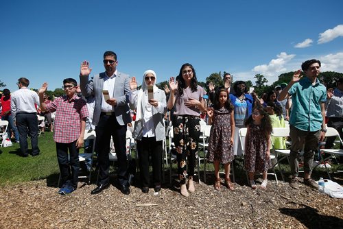 JOHN WOODS / WINNIPEG FREE PRESS
Mahmoud Al-Abedi and Rola Elsousi and their children, from left, Naser,  Marah, Zaina and Dana swear an oath during their citizenship ceremony on  Canada Day at Assiniboine Park, Sunday, July 1, 2018.