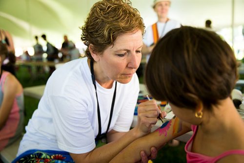 MIKAELA MACKENZIE / WINNIPEG FREE PRESS
Carla Dorbolo, head of face painting at the family area, paints six-year-old Ranya Zndnan's face at the Winnipeg Folk Fest in Bird's Hill Provincial Park on Friday, July 6, 2018. 
Mikaela MacKenzie / Winnipeg Free Press 2018.