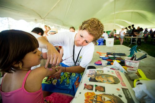 MIKAELA MACKENZIE / WINNIPEG FREE PRESS
Carla Dorbolo, head of face painting at the family area, paints six-year-old Ranya Zndnan's face at the Winnipeg Folk Fest in Bird's Hill Provincial Park on Friday, July 6, 2018. 
Mikaela MacKenzie / Winnipeg Free Press 2018.