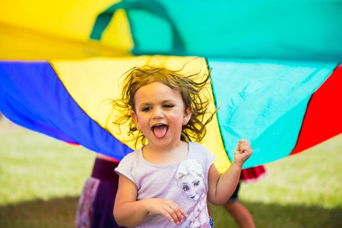 MIKAELA MACKENZIE / WINNIPEG FREE PRESS
Ennya McLaren, three, plays in the parachute at the Winnipeg Folk Fest in Bird's Hill Provincial Park on Friday, July 6, 2018. 
Mikaela MacKenzie / Winnipeg Free Press 2018.