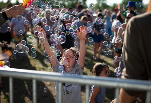 ANDREW RYAN / WINNIPEG FREE PRESS A child enjoys a a flurry of bubbles at the front rows at the main stage of innipeg Folk Fest in Birds Hill Provincial Park on July 6, 2018.