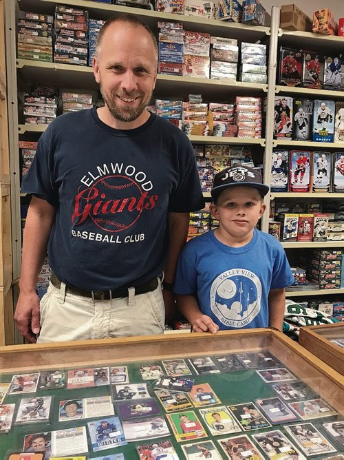 Canstar Community News Mike Bergmann, owner of Lower Level Sports Cards & Collectibles, and son Wyatt are boosters of Elmwood Giants baseball. (SHELDON BIRNIE/CANSTAR/THE HERALD)