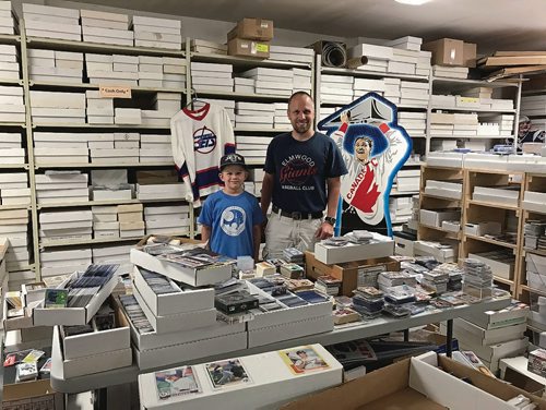 Canstar Community News Lower Level Sports Cards & Collectibles (1-189 Henderson Hwy.) recently acquired the remaining stock of Face-Off Sports Cards, which closed up its shop in St. James last month. Pictured, from left, Wyatt and Mike Bergmann, owner of Lower Level Sports Cards. (SHELDON BIRNIE/CANSTAR/THE HERALD)