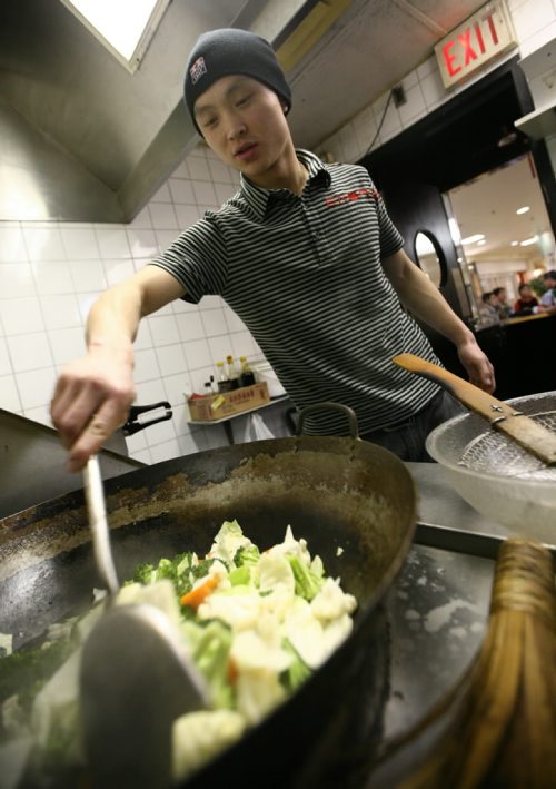 Brandon Sun 24012009 Head Chef Thomas Li cooks vegetables at K S Oriental Food in the Town Centre while doing a practice run for the Winterfest Chinese Pavilion on Saturday afternoon. (Tim Smith/Brandon Sun)