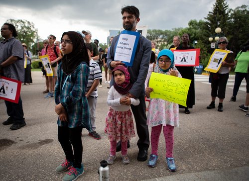 ANDREW RYAN / WINNIPEG FREE PRESS Father Imran Rahman with children Ride, left, Marwa and Manal at a protest in support of refugees suffering through boarder politics in North America on July 11, 2018.