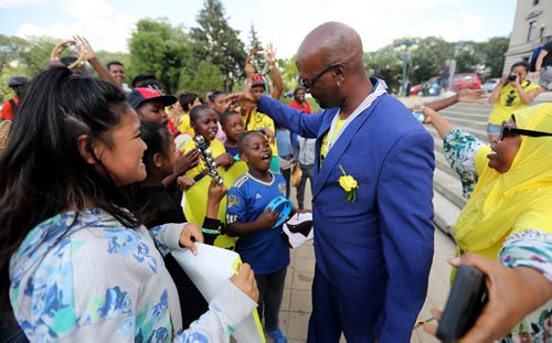 TREVOR HAGAN / WINNIPEG FREE PRESS
Ken Opaleke, executive director of the West Broadway Youth Outreach organization is mobbed after he, and 11 others received the Order of Manitoba during a ceremony at the Legislative Building, Thursday, July 12, 2018.