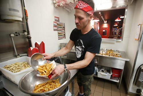 JOHN WOODS / WINNIPEG FREE PRESS
Keith Mercier, kitchen manager at Smokes Poutinerie, serves up some poutine in Winnipeg Friday, July 13, 2018. This is part of the 24hourproject

