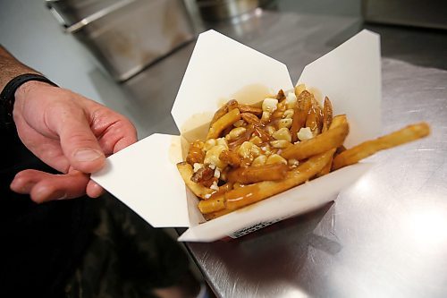 JOHN WOODS / WINNIPEG FREE PRESS
Keith Mercier, kitchen manager at Smokes Poutinerie, serves up some poutine in Winnipeg Friday, July 13, 2018. This is part of the 24hourproject