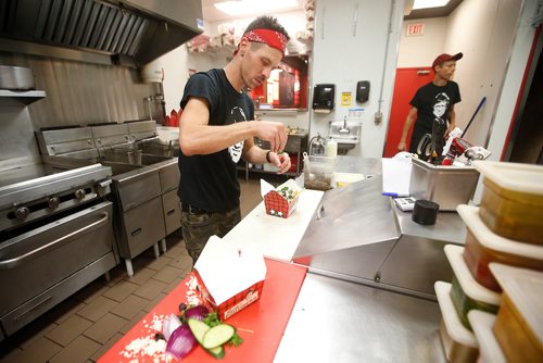 JOHN WOODS / WINNIPEG FREE PRESS
Keith Mercier, kitchen manager at Smokes Poutinerie, serves up some poutine in Winnipeg Friday, July 13, 2018. This is part of the 24hourproject

