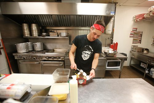 JOHN WOODS / WINNIPEG FREE PRESS
Keith Mercier, kitchen manager at Smokes Poutinerie, serves up some poutine in Winnipeg Friday, July 13, 2018. This is part of the 24hourproject

