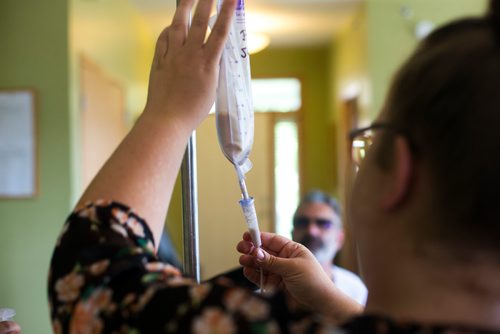 MIKAELA MACKENZIE / WINNIPEG FREE PRESS
Support worker Samantha Franklin adjust the flow of the drip-fed system while Benjamin Brubacher, 31, gets tube fed in his group home in Winnipeg on Friday, July 13, 2018. 24hourproject
Mikaela MacKenzie / Winnipeg Free Press 2018.