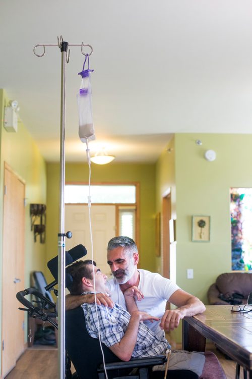 MIKAELA MACKENZIE / WINNIPEG FREE PRESS
Benjamin Brubacher, 31, and his dad, Mark, spend time together while Benjamin gets tube fed in his group home in Winnipeg on Friday, July 13, 2018. 24hourproject
Mikaela MacKenzie / Winnipeg Free Press 2018.