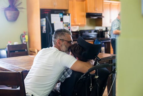 MIKAELA MACKENZIE / WINNIPEG FREE PRESS
Benjamin Brubacher, 31, and his dad, Mark, spend time together while Benjamin gets tube fed in his group home in Winnipeg on Friday, July 13, 2018. 24hourproject
Mikaela MacKenzie / Winnipeg Free Press 2018.