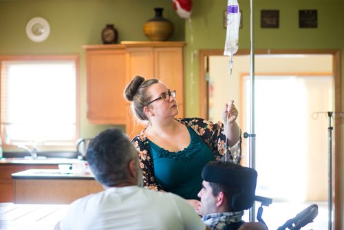 MIKAELA MACKENZIE / WINNIPEG FREE PRESS
Support worker Samantha Franklin adjust the flow of the drip-fed system while Benjamin Brubacher, 31, gets tube fed in his group home in Winnipeg on Friday, July 13, 2018. 24hourproject
Mikaela MacKenzie / Winnipeg Free Press 2018.