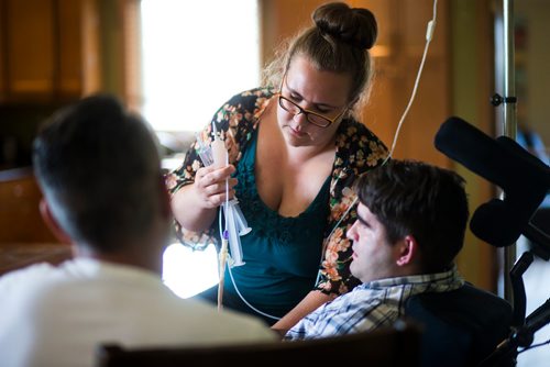 MIKAELA MACKENZIE / WINNIPEG FREE PRESS
Support worker Samantha Franklin finishes tube feeding Benjamin Brubacher, 31, in his group home in Winnipeg on Friday, July 13, 2018. 24hourproject
Mikaela MacKenzie / Winnipeg Free Press 2018.