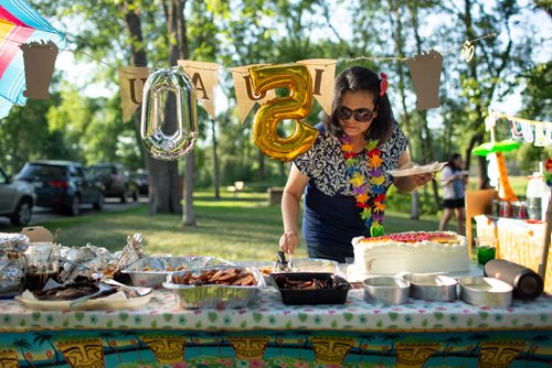 ANDREW RYAN / WINNIPEG FREE PRESS Gina Arroza serves herself last after being surprised by her family and co-workers with a 50th birthday bash in Kildonan Park Friday, July 13, 2018. FOR STACEY THIDRICKSONS 7 P.M. GATHERING IN KILDONAN PARK, 24-HOUR FOOD FOR THOUGHT PROJECT 24hourproject