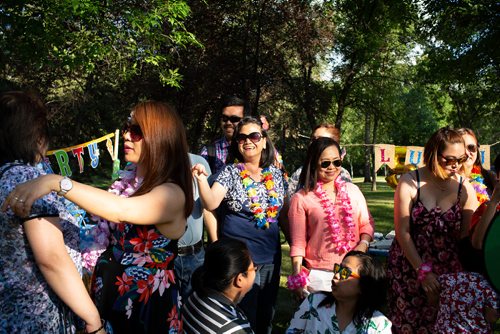 ANDREW RYAN / WINNIPEG FREE PRESS Gina Arroza (second from left, in blue and white shirt) beams after being surprised with a 50th birthday bash in Kildonan Park Friday, July 13, 2018. Her co-workers, including Antonia Guevarra (far left, wearing watch, preparing to hug party guest), Argen Daypal (second from right, in pink shirt) and Hazel Legaspi (right, in strappy flowered dress), helped organize the soirée. 
FOR STACEY THIDRICKSONS 7 P.M. GATHERING IN KILDONAN PARK, 24-HOUR FOOD FOR THOUGHT PROJECT 24hourproject