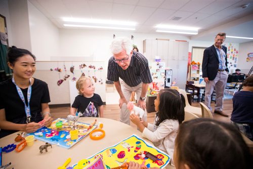 MIKAELA MACKENZIE / WINNIPEG FREE PRESS
Jim Carr, Member of Parliament for Winnipeg South Centre, says hello to children (Ben Krichkowski, left, and Jayrelle Rumarate) at Harrow Co-op Childrens Centre in Winnipeg on Thursday, July 19, 2018. 
Mikaela MacKenzie / Winnipeg Free Press 2018.