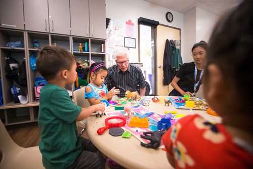 MIKAELA MACKENZIE / WINNIPEG FREE PRESS
Jim Carr, Member of Parliament for Winnipeg South Centre, says hello to Madeleine Joyce Rivo at Harrow Co-op Childrens Centre in Winnipeg on Thursday, July 19, 2018. 
Mikaela MacKenzie / Winnipeg Free Press 2018.