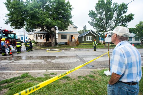 MIKAELA MACKENZIE / WINNIPEG FREE PRESS
A neighbour watches as firefighters clean up at a house fire at Arlington and Ellice in Winnipeg on Friday, July 20, 2018. 
Mikaela MacKenzie / Winnipeg Free Press 2018.