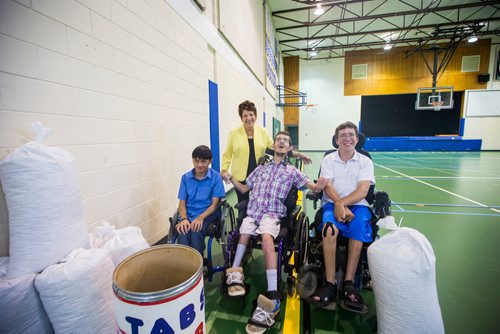 MIKAELA MACKENZIE / WINNIPEG FREE PRESS
Marlon Calakhan (left), Bryce Thiessen, and Luke Savoie with Tabs founder Gwen Buccini pose with some bags of tabs at Holy Cross School in Winnipeg on Thursday, July 19, 2018. All three received the wheelchairs they are using from Tabs for Wheelchairs.
Mikaela MacKenzie / Winnipeg Free Press 2018.