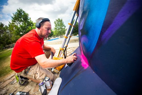 MIKAELA MACKENZIE / WINNIPEG FREE PRESS
London-based artist Mr Cenz works on a mural on the outside of the skate bowl at the Forks in Winnipeg on Friday, July 20, 2018. 
Winnipeg Free Press 2018.