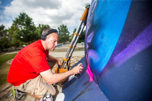 MIKAELA MACKENZIE / WINNIPEG FREE PRESS
London-based artist Mr Cenz works on a mural on the outside of the skate bowl at the Forks in Winnipeg on Friday, July 20, 2018. 
Winnipeg Free Press 2018.