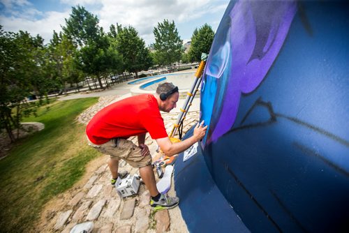 MIKAELA MACKENZIE / WINNIPEG FREE PRESS
London-based artist Mr Cenz works on a mural on the outside of the skate bowl at the Forks in Winnipeg on Friday, July 20, 2018. 
Winnipeg Free Press 2018.