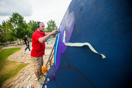 MIKAELA MACKENZIE / WINNIPEG FREE PRESS
London-based artist Mr Cenz works on a mural on the outside of the skate bowl at the Forks in Winnipeg on Friday, July 20, 2018. 
Winnipeg Free Press 2018.