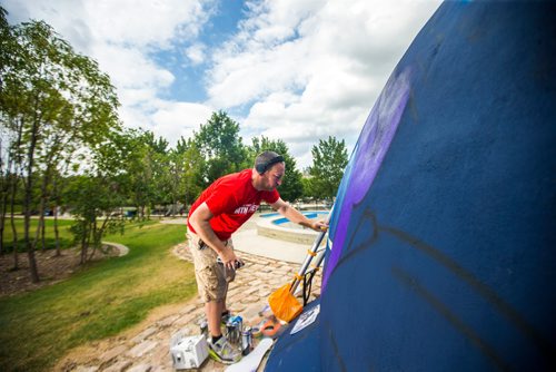 MIKAELA MACKENZIE / WINNIPEG FREE PRESS
London-based artist Mr Cenz works on a mural on the outside of the skate bowl at the Forks in Winnipeg on Friday, July 20, 2018. 
Winnipeg Free Press 2018.