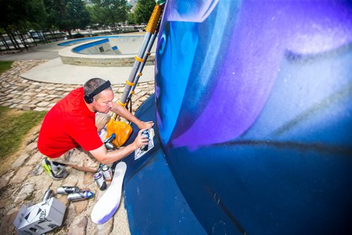 MIKAELA MACKENZIE / WINNIPEG FREE PRESS
London-based artist Mr Cenz works on a mural on the outside of the skate bowl at the Forks in Winnipeg on Friday, July 20, 2018. 
Winnipeg Free Press 2018.