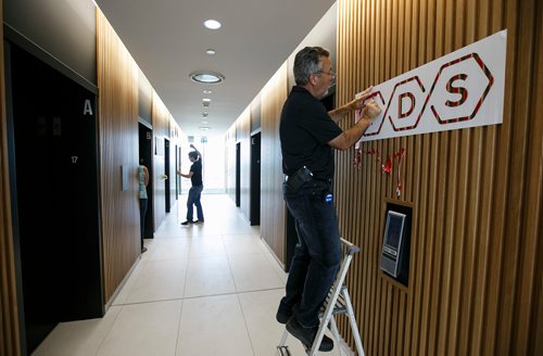 MIKE DEAL / WINNIPEG FREE PRESS
Larry Neudorf installs the TDS law firm logo in the elevator lobby on the 17th floor of their new offices at True North Square Monday morning.
180723 - Monday, July 23, 2018.