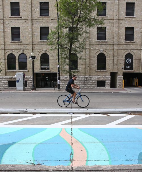 MIKE DEAL / WINNIPEG FREE PRESS
Cyclists in the Exchange District Tuesday morning. 
180724 - Tuesday, July 24, 2018.
