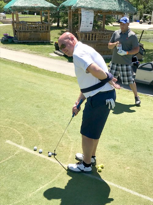 SUBMITTED PHOTO

Ron Neufeld tries to sink a putt with a arm tied behind his back at the La Salle Insurance and Travel Ltd. Charity Golf Tournament held at Kingswood Golf & Country Club on June 28, 2018 to raise funds for the Society for Manitobans with Disabilities (SMD) Assistive Technology Program. (See Social Page)