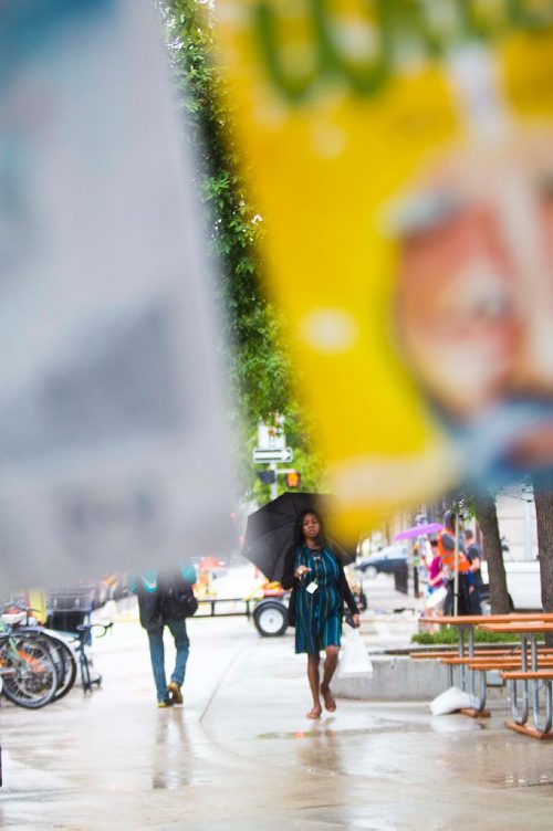 MIKAELA MACKENZIE / WINNIPEG FREE PRESS
Emmanuella walks past Old Market Square on a rainy day at the Fringe Festival in Winnipeg on Wednesday, July 25, 2018. 
Winnipeg Free Press 2018.