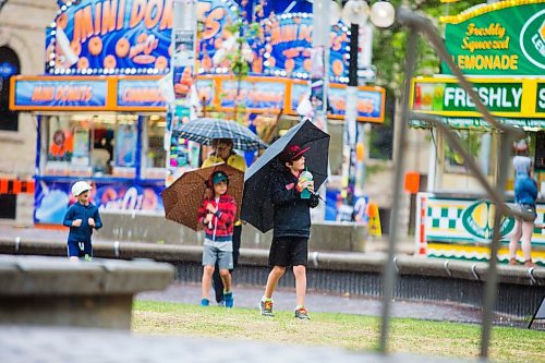 MIKAELA MACKENZIE / WINNIPEG FREE PRESS
Hayden Thiem walks through Old Market Square with a lemonade and an umbrella on a rainy day at the Fringe Festival in Winnipeg on Wednesday, July 25, 2018. 
Winnipeg Free Press 2018.