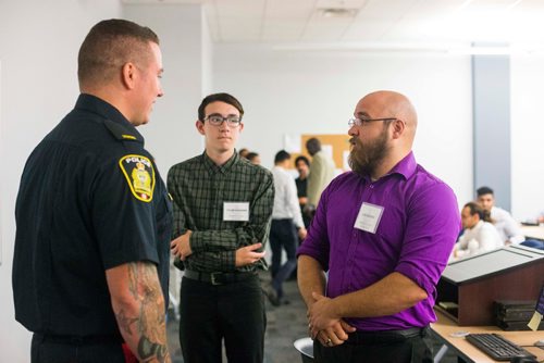 MIKAELA MACKENZIE / WINNIPEG FREE PRESS
Constable Shawn Smith talks to Les Marsh at the Winnipeg Police Service Diversity Career Exhibition, open to Indigenous and newcomer community members interested in a career in law enforcement, at the Winnipeg Police Headquarters in Winnipeg on Thursday, July 26, 2018. 
Winnipeg Free Press 2018.