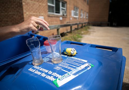 ANDREW RYAN / WINNIPEG FREE PRES Reporter Jill Wilson places items which cannot be recycled onto a bin to be moved to a garbage receptacle. Wilson went through Wolseley residents' recycling bins for misplaced items on July 26, 2018.