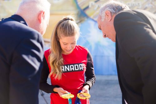 MIKAELA MACKENZIE / WINNIPEG FREE PRESS
Kaitlyn Lawes takes a look at her hardware with St. Vital Curling Club president Ken Stevens (left) and Take Pride Winnipeg executive director Tom Ethans with in front of St.Vital Curling Club's newest mural, commemorating her gold medal win in mixed doubles, in Winnipeg on Friday, July 27, 2018. 
Winnipeg Free Press 2018.
